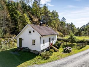 a small white house on the side of a road at Det Hvite Hus - Fosseland Hytter in Feda