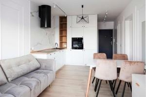 a living room with a couch and a table and chairs at Sami Swoi 1 in Bełchatów
