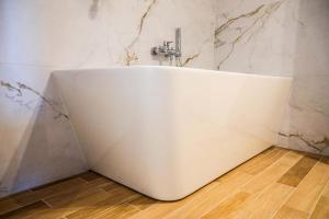 a white bath tub in a bathroom with a faucet at Sami Swoi 1 in Bełchatów