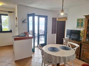 a kitchen and dining room with a table and a television at Holiday house Jakov in Gdinj