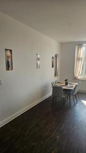 a dining room with a table and chairs and paintings at Die Schöne Wohnung am Stade Bahnof in Stade