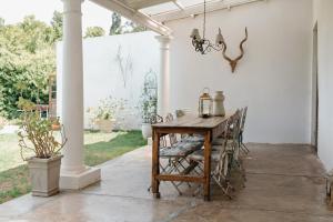 a porch with a wooden table and chairs at Hawksmoor House in Stellenbosch
