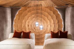 a living room with two white couches and a wooden wall at Chalets Grossmitt in Pertisau