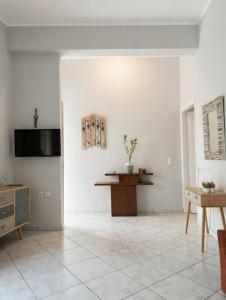 a living room with white walls and a tiled floor at Mairi’s Apartment in Nea Artaki +5 photos
