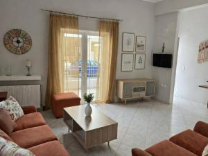 a living room with a couch and a table at Mairi’s Apartment in Nea Artaki