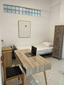 a room with a desk and a laptop on a table at Mairi’s Apartment in Nea Artaki