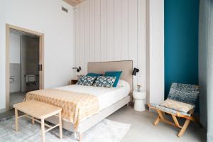 a bedroom with a bed and a chair at Apartamentos Territorios in Mérida