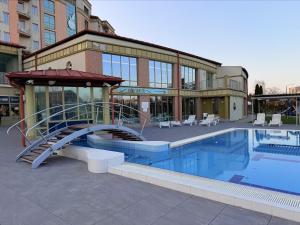 a swimming pool with a slide in front of a building at Tóth Wellness Apartman in Zalakaros