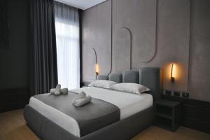 a bedroom with a large bed with two towels on it at Hotel Bel Ami Tirana in Tirana
