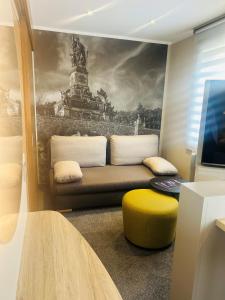 a living room with a couch and a yellow stool at Hotel Rose in Rüdesheim am Rhein