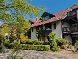 ein großes Haus mit rotem Dach in der Unterkunft Ferien Hotel Cottbus in Kolkwitz