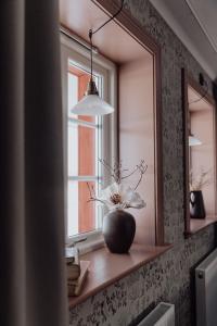 a vase on a window sill with a flower in it at Trakt Forest Hotell Gårdshotell in Holsbybrunn +51 photos