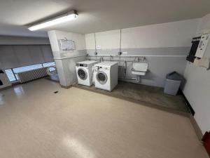 a laundry room with a washing machine and a washer and dryer at Family Apartment History 5 Gäste Air Condition Parken Frei in Munich