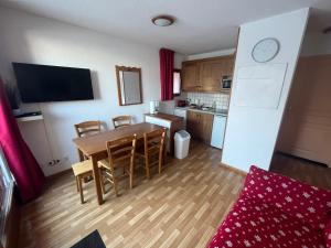 a kitchen and dining room with a table and chairs at Appartement 4-6 personnes à Puy-Saint-Vincent in Puy-Saint-Vincent