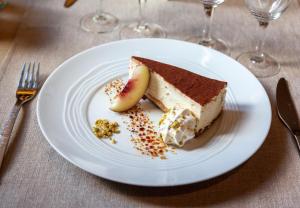 a piece of cake on a white plate on a table at LOGIS Hôtel & Restaurant - Au Bord du Lac in Saint-Rémy-lès-Chevreuse +28 photos