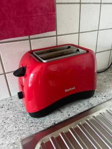 a red toaster sitting on top of a counter at Appartement 4-6 personnes à Puy-Saint-Vincent in Puy-Saint-Vincent