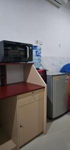 a microwave sitting on top of a counter next to a refrigerator at Jepun Segara Guest House in Kuta