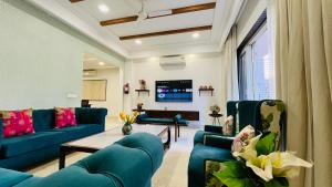 a living room with blue couches and a tv at BluO Medicity - Boutique Hotel Gurgaon in Gurgaon