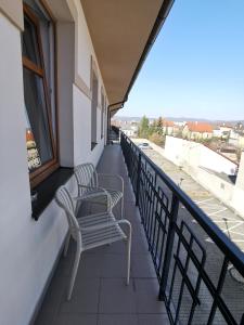 two chairs sitting on the balcony of a building at Apartmán Stará Tržnica in Trenčín