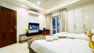 a bedroom with two beds and a television in it at BluO Medicity - Boutique Hotel Gurgaon in Gurgaon