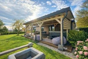a house with a pergola and a grill in a yard at Woodland cottage in Balatonfůzfő