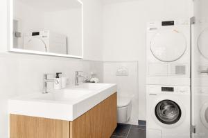 a bathroom with a sink and a washing machine at Bad Aibling Apartments in Bad Aibling +15 photos