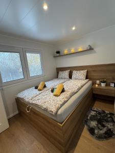 a bedroom with a large bed with yellow pillows at Woodland cottage in Balatonfůzfő