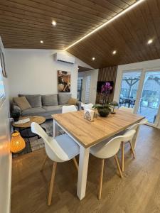 a dining room with a wooden table and white chairs at Woodland cottage in Balatonfůzfő