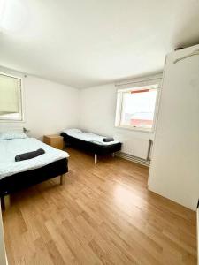 a room with two beds and two windows at Workers Stay - Staff Accommodation Säve - Göteborg in Säve