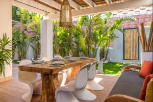 a wooden table and chairs in a room with plants at Can Tau Cala Tarida in Sant Josep de sa Talaia