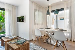 a living room with a table and two white chairs at Can Tau Cala Tarida in Sant Josep de sa Talaia
