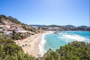 a view of a beach with people and the ocean at Can Tau Cala Tarida in Sant Josep de sa Talaia