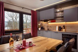 a kitchen with a wooden table with wine glasses at Alpenchalet am Lech in Ehenbichl