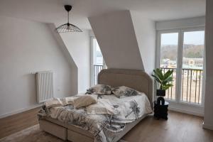 a bedroom with a bed and a large window at Cocon Seine parisii in Sartrouville