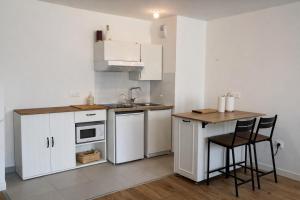 a small kitchen with white cabinets and a table at Cocon Seine parisii in Sartrouville
