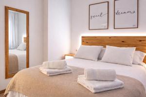 a bedroom with a large white bed with towels on it at Sentir CAZORLA in Cazorla +17 photos