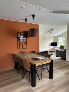 a dining room with a wooden table and chairs at T Skûttegat in Hollum
