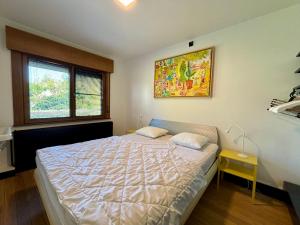 a bedroom with a bed and a painting on the wall at Villa Bonheur in Koksijde