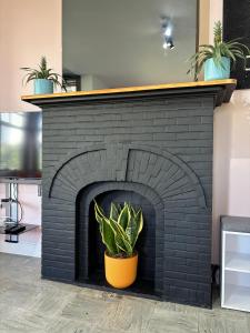 a black brick fireplace with a potted plant at Villa Bonheur in Koksijde