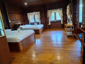 a bedroom with two beds and a wooden floor at Tribal Pai in Pai
