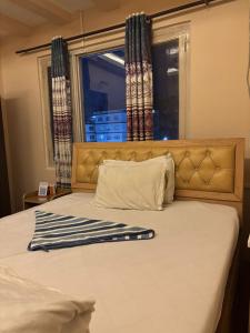a bedroom with a bed with a window with curtains at Hotel Syangbo Brothers in Kathmandu