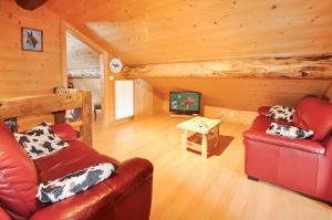 a living room with a red couch and a table at Chalet Alpage in Les Crosets