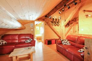 a living room with a red couch and a table at Chalet Alpage in Les Crosets