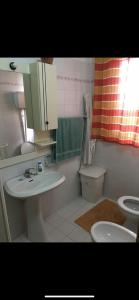 a bathroom with a sink and a toilet and a mirror at Baglio Cusenza Rooms in San Vito lo Capo