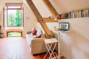 a living room with a couch and a laptop on a desk at Water Mill - Private Lake - Fiber Wifi - Burgundy in Rix