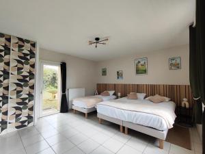 a bedroom with two beds and a window at L'Orée du Puy in Les Herbiers