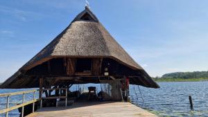 eine Hütte am Ende eines Stegs im Wasser in der Unterkunft ZWEITE REIHE FLAIR Ferienwohnungen in Krakow am See