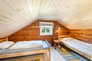 a room with two beds in a log cabin at Det Hvite Hus - Fosseland Hytter in Feda