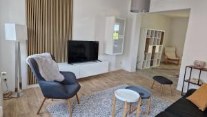 ein Wohnzimmer mit Sofa und Fernseher in der Unterkunft ZWEITE REIHE FLAIR Ferienwohnungen in Krakow am See