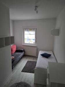 ein kleines Zimmer mit einem Bett und einer Couch in der Unterkunft ZWEITE REIHE FLAIR Ferienwohnungen in Krakow am See